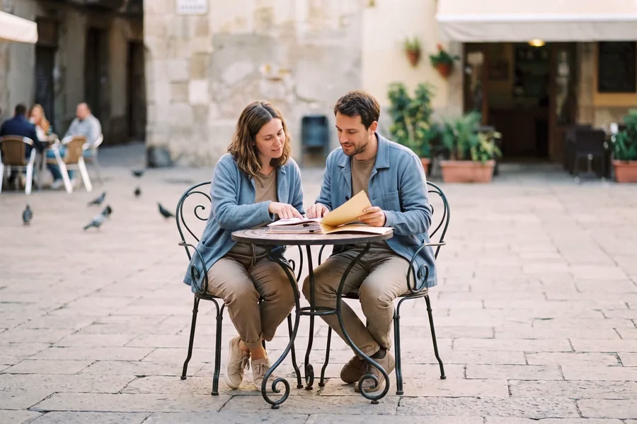 Pareja revisando documentación en una terraza en España